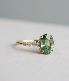 an oval cut green and white diamond ring