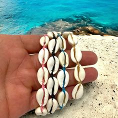 "Embrace the essence of the ocean with our handcrafted Cowry Shell Bracelet/Anklet. Each piece is a symphony of natural elegance, featuring authentic cowry shells that have been carefully selected for their unique beauty. These shells, treasured for centuries as symbols of prosperity and good luck, now adorn your wrist or ankle in a dance of bohemian charm. Our versatile design allows for an adjustable fit, ensuring that you can wear it comfortably as a bracelet or anklet, making it the perfect Shell Bracelet Jewelry For Vacation, Shell Jewelry Bracelet For Vacation, Beachy Shell Bracelet Jewelry, Adjustable Shell Bracelets For Beach Season, Beaded Shell Strand Bracelets, Adjustable Gold Wrap Bracelet For The Beach, Adjustable Beaded Shell Bracelets, Adjustable Coastal Style Bracelet Jewelry, Coastal Style Adjustable Bracelet Jewelry