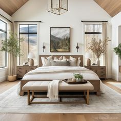 a large bed sitting in a bedroom next to two windows and a rug on top of a wooden floor