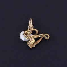 Antique Dragon Charm: Unlock the magic of ancient lore with this enchanting charm, crafted from 14k gold and adorned with a lustrous pearl. Originally an antique stickpin from circa 1890, our skilled jeweler transformed it into a charm by removing the pin and adding a 14k gold jump ring bail. The petite charm measures 0.6 inches from the top of the jump ring to bottom by 0.5 inches wide, and it is in great condition. We have many other fantastic offerings of period fine and costume jewelry poste Art Nouveau Rose Gold Jewelry As A Gift, Ceremonial Yellow Gold Jewelry With Charms, Art Nouveau Rose Gold Jewelry As Gift, Art Nouveau Rose Gold Jewelry For Gift, Art Nouveau Rose Gold Jewelry Gift, Rose Gold Art Nouveau Jewelry For Gift, Ceremonial Gold Art Nouveau Jewelry, Antique Rose Gold Jewelry For Ceremonial Occasions, Art Nouveau Gold Collectible Jewelry