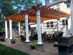 an outdoor grill and pergolated patio area