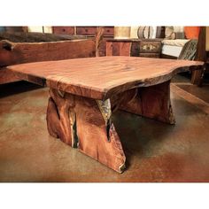 a wooden table sitting on top of a floor next to couches in a room