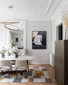 an elegant dining room with white walls and wood floors