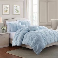 a bed with blue comforters and pillows in a room