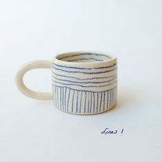 a white and blue striped mug sitting on top of a table