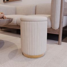 a white couch sitting next to a table with a bowl on it's side