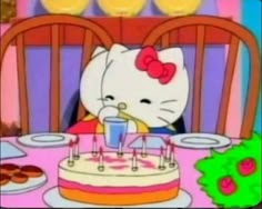 hello kitty is blowing out the candles on her birthday cake while sitting at a table