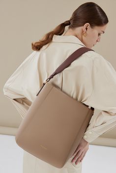 The Carrie Medium Tote Bag's rectangular silhouette sits perfectly on the shoulder, with a wide leather strap that is adjustable with the belt loop detail. Lined with smooth leather, the bag can fit an 13" laptop, making it an ideal everyday tote. Optional Add-ons: Webbing Shoulder Strap; AirPods Pro Case. Rectangular Bucket Bag With Detachable Strap For Work, Modern Rectangular Laptop Bag With Detachable Handle, Rectangular Bucket Bag With Removable Pouch For Work, Classic Crossbody Bucket Bag For Work, Rectangular Workwear Bucket Bag With Removable Pouch, Chic Brown Laptop Bag With Adjustable Strap, Workwear Rectangular Bucket Bag With Removable Pouch, Rectangular Hobo Bag With Removable Pouch For Work, Modern Bag Strap With Removable Pouch For Daily Use