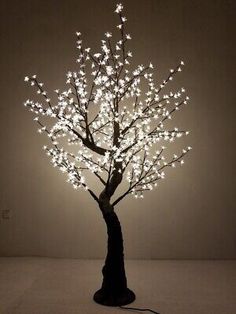 a lighted tree in the shape of a lamp with white lights on it's branches