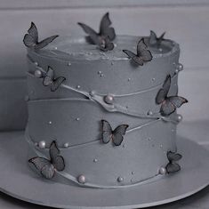 there is a cake with butterflies on the frosting and white icing, along with pearls