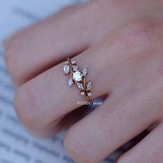 a close up of a person's hand wearing a gold ring with diamonds on it