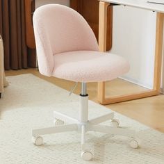 a pink office chair sitting on top of a white rug in front of a desk