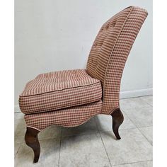 an upholstered chair sitting on top of a tile floor