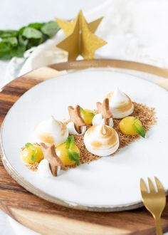 a white plate topped with dessert on top of a wooden cutting board next to a gold star