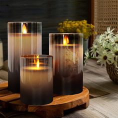 three lit candles sitting on top of a wooden table