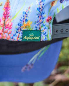 an alpinehoo hat is hanging on the back of someone's blue hat