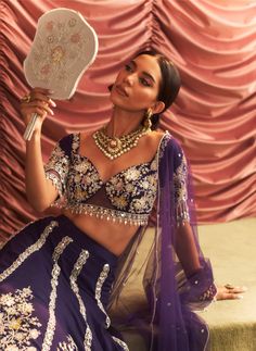 Make a grand entrance in this stunning purple embellished blouse, paired with a voluminous lehenga featuring cancan for added flair and drama. The matching dupatta completes the ensemble, creating a captivating look that is perfect for weddings and festive celebrations. Regal Aesthetic, Purple Lehenga, Yellow Hues, Vacuum Storage, Embroidered Lehenga, Indian Wedding Wear, Lehenga Blouse, Embroidered Dupatta, Embellished Blouse