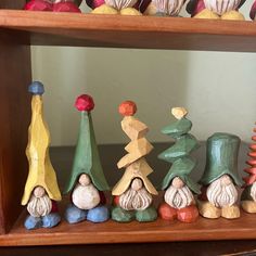 small wooden gnomes are lined up on the shelf in front of eachother