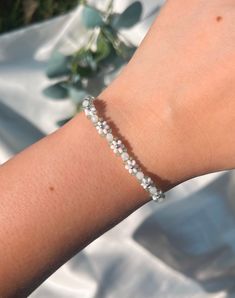 This beaded daisy bracelet is hand-woven using miyuki seed beads. This bracelet features white daisies, white round beads, and sage green beads in between with a silver accent center bead and sterling silver hardware (clasp & jump rings).  𝓂𝒶𝓉𝑒𝓇𝒾𝒶𝓁𝓈 ❁ Clasp and Jump rings:  Sterling Silver (clasp and Jump rings) ❁ High-Quality 3mm Japanese Seed Beads ❁ Monofilament Cord (non-stretch) Silver Seed Bead Bracelets, Delicate White Bracelets For Spring, White Delicate Bracelet For Spring, Delicate White Bracelet For Spring, Delicate White Adjustable Friendship Bracelets, White Delicate Adjustable Friendship Bracelets, Delicate Adjustable White Friendship Bracelets, Minimalist White Jewelry For Spring, Handmade White Crystal Bracelet With Flower Shape