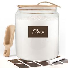 there is a jar with flour in it and a wooden spoon next to it