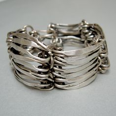 "Sterling silver cuff bracelet, worked by the craftsmanship of the long hammered links that have created a \"fabric\" effect. The \"Fabric 4X3\" bracelet is one of my most successful creations, I make it order, each piece is to be considered unique, by virtue of the completely manual processing of the hammered links. A stylish bracelet that certainly does not go unnoticed, \"Fabric 4X3\" still manages to be a jewel easy to wear even every day. Weight 54 g Length 18 cm Width 3 cm Thank you for vi Elegant Link Bracelet With Oxidized Finish, Elegant Oxidized Link Bracelets, Modern Cuff Bracelet With Oxidized Finish, Modern Silver Cuff Bracelet With Oxidized Finish, Handmade Elegant Sterling Silver Link Bracelet, Elegant Metal Cuff Bracelet With Oxidized Finish, Modern Hammered Silver Bracelets, Modern Silver Hammered Bracelets, Modern Handmade Silver Bracelets