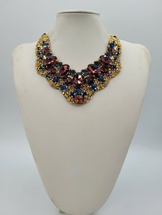 Each piece of our statement necklaces is handmade and one of a kind made in Italy. Our creations is made of high quality materials such as crystals and rhinestones. Each embroidered material is carefully hand sewn. Very glamorous and stylish. Perfect gift to someone you like. Materials Strass stone and Rhinestone in Burgungy and Montana color in different dimension.  Black satin fabric backing. Aluminium chain with lobster closure. Measurements Weight approximate 200 grams. Chain lenght 25 cm - 9.84 in Circumference approximate 63 cm - 24.80 in Feel free to contact us if you have any question. Thank you so much for looking at our shop and our articles each of them, single piece. Costume Jewelry Jeweled Choker Necklace, Luxury Handmade Multicolor Necklaces, Luxury Handmade Beaded Necklaces For Party, Luxury Handmade Multicolor Necklace, Handmade Luxury Beaded Necklace For Parties, Luxury Handmade Beaded Necklace For Party, Luxury Handmade Beaded Party Necklace, Handmade Formal Choker Necklace, Formal Handmade Choker Necklace