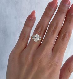 a woman's hand with a diamond ring on her left hand, and a white background