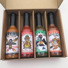 four bottles of hot sauce in a cardboard box