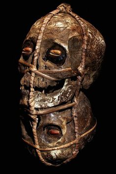 an old mask with wire wrapped around it's face and eyes, against a black background