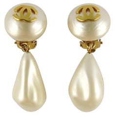 CHANEL vintage faux pearl dangling earrings (clip-on) featuring a gold toned CC logo and a Baroque irregular-shaped glass faux pearl drop. Embossed CHANEL. Indicative measurements : height approx. 4.3 cm (1.69 inches) / max. width approx. 1.6 cm (0.63 inch). IMPORTANT INFORMATION Please note that from original manufacturing, the size/shape of the faux pearl drops are slightly different. NOTES - This is a preloved vintage item, therefore it might have imperfections. - Colors may differ slightly f 90s Girl Fashion, Vintage Chanel Earrings, Long Pearl Earrings, Jewelry Classic, Chanel Outfit, Chanel Pearls, Vintage Pearl, Earrings Clip, Chanel Earrings