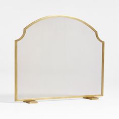 a white and gold fireplace screen with an arched design on the front, standing upright