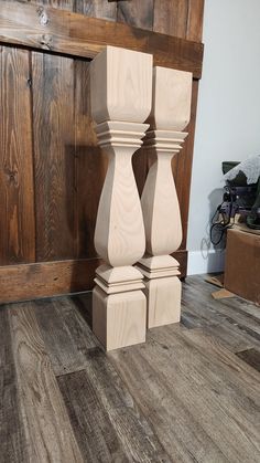 three wooden candlesticks are stacked on top of each other in front of a wood paneled wall