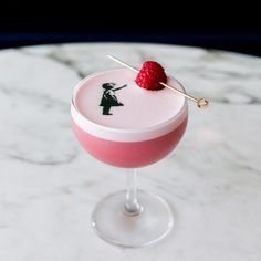 a pink cocktail with strawberries on the rim