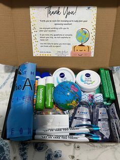 an open box filled with personal care items on top of a bed next to a thank you sign