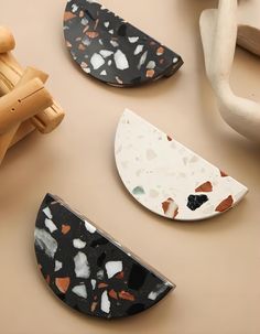 three pieces of pottery sitting on top of a table next to wooden spoons and toothbrushes