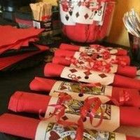 the table is set up with cards and utensils for playing cards in red