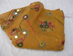 Pattern - embroidered sequin scarf. Ideal for - women/ girls. Occasion - formal or casual. Fabric - cotton. It has an embroidered floral pattern all over. This piece is from the Kutchh area of Gujarat. It is hand-painted and embroidered. Color - On a light yellow background, embroidery is done with different colored threads and mirror sequins. Plastic sequins are used because they are lightweight. Size - 40 x 84 inches(approx). Care - gentle hand wash. For more such scarves please visit- https:/ Traditional Cotton Shawl For Spring, Bohemian Multicolor Embroidered Dupatta For Summer, Bohemian Yellow Dupatta For Spring, Traditional Beige Dupatta For Summer, Multicolor Cotton Shawl For Festivals, Cotton Embroidered Fabric With Handwork For Festivals, Bohemian Style Multicolor Embroidered Dupatta For Summer, Traditional Embroidered Shawl For Summer, Yellow Cotton Dupatta For Summer