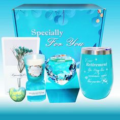 a blue gift box with candles, candle holder, and other items in the package