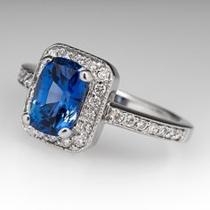 This gorgeous no heat blue sapphire ring is centered with a 1.64 carat cushion cut sapphire set into a four-prong head and is bordered with eighteen (18), bead set, round brilliant cut diamonds. The top face of the shank is accented with a row of seven (7), bead set, round brilliant cut diamonds on each side. The ring measures 10.2mm at the top, rises 6.4mm above the finger, tapering to 1.7mm wide and 1.1mm thick at the base of the shank. The ring is currently a size 4.75 and we offer complimentary resizing to fit. Blue Sapphire Engagement Ring, Blue Sapphire Ring, Sapphire Engagement Ring Blue, Sapphire Engagement Ring, Bead Set, No Heat, Blue Sapphire Rings, Sapphire Engagement, Diamond Halo