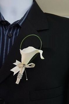 a white flower is attached to a black jacket