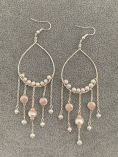 These teardrop earrings are lightweight while giving length. Every teardrop is lined with 8 small freshwater pearls, the other beads are cream colored glass beads. Teardrop Pearl Drop Chandelier Earrings For Party, Teardrop Chandelier Earrings With Pearl Drop, Teardrop Pearl Drop Chandelier Earrings, Party Pearl Drop Long Teardrop Earrings, Pearl White Dangle Chandelier Earrings With Pearl Drop, Pearl Drop Chandelier Earrings, Party Long Drop Pearl Teardrop Earrings, Party Long Drop Teardrop Earrings With Pearl, Cream Teardrop Pearl Drop Jewelry