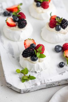 small desserts with berries and whipped cream are on a tray, ready to be eaten