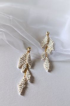 Delicate, Handmade Wedding Earrings Dreaming of unique jewelry for your wedding? Our handmade earrings are the perfect choice!  Crafted from high-quality materials: gold-plated wire, pearly seed beads, and hypoallergenic stainless steel studs, they will enchant you with their delicate beauty.  Thanks to the two-part design, you can wear them both long and short, adapting them to any style. Ideal for weddings, but also for many other occasions. Earrings measurement: * Full length: approx 8cm (3.1 Dainty White Pearl Drop Chandelier Earrings, Delicate Dangling Beads Earrings For Wedding, White Dangle Earrings For Wedding Gift, White Pearl Drop Dangle Cluster Earrings, White Teardrop Cluster Earrings For Party, Handmade White Chandelier Earrings For Anniversary, White Pearl Drop Cluster Earrings, Dainty White Dangle Bridal Earrings, Delicate Pearl Earrings With Dangling Beads