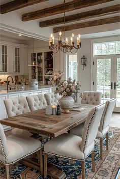 a dining room table with chairs and a chandelier hanging from the ceiling above it