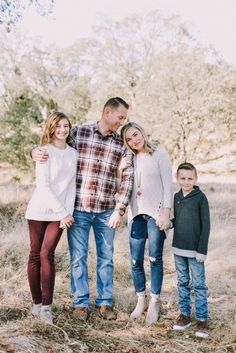 a family posing for a photo in the woods