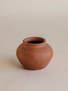 a brown vase sitting on top of a white table