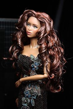 a doll with long brown hair wearing a black dress