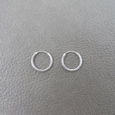 A great pair of simple, everyday wear Sterling Silver Hoops.These hoops measure 12mm.They are made of sterling silver and are great for those with sensitive ears.Mix and match with my other stud and hoop earringsThis listing is for one pair (2 pieces). Guys Ear Piercings, Hoop Earrings Aesthetic, Simple Silver Earrings, Small Silver Hoop Earrings, Simple Hoop Earrings, Tiny Hoop Earrings, Pretty Jewelry Necklaces, Simple Stud Earrings, Jewelry Aesthetic