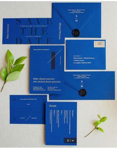 a blue wedding suite with matching envelopes and save - the - date cards are on display