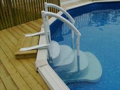 an above ground swimming pool with steps leading to the water and decking around it